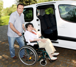 man helping an elderly woman in wheelchair